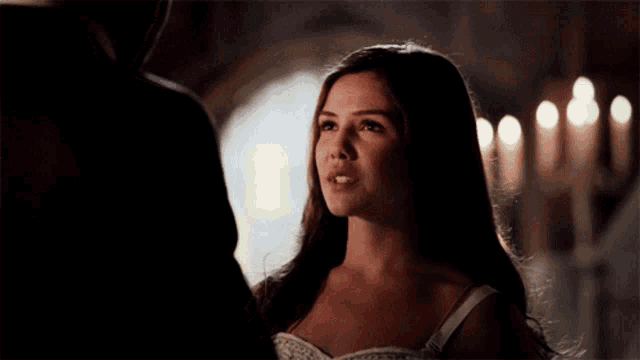 a woman in a white dress is looking at a man in a suit
