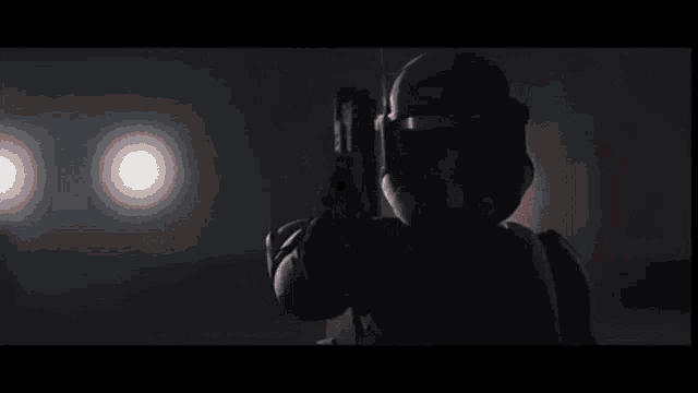 a close up of a person holding a gun in the dark .