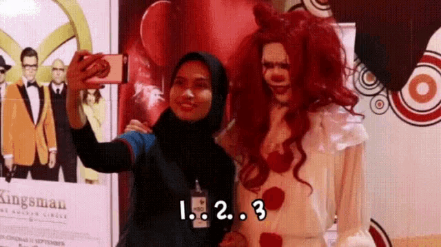 a woman taking a selfie with a clown in front of a sign that says ' kingsman '