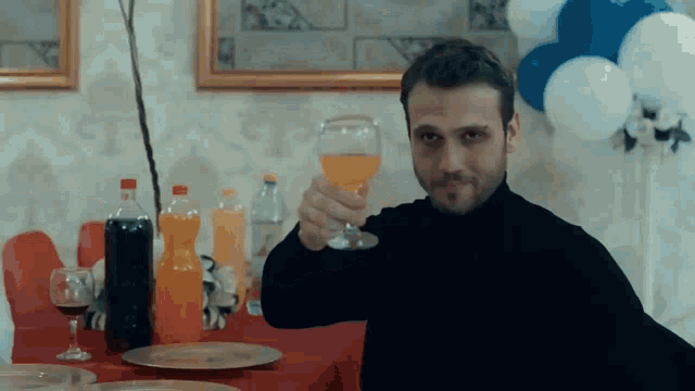a man sitting at a table with a glass of orange juice