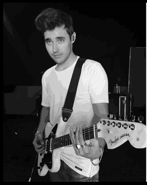 a young man playing a fender jaguar guitar