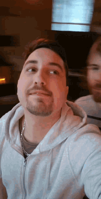 a man with a beard is taking a selfie with his reflection