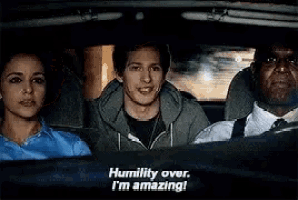 a group of people are sitting in a car and one of them is saying humility over .