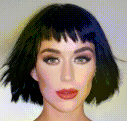 a woman with short black hair and red lips is wearing a wig .