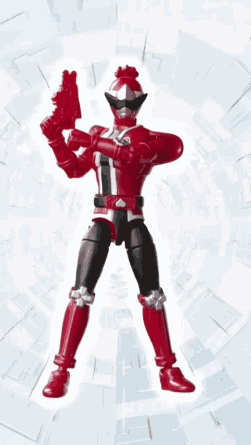 a red and black action figure is holding a gun