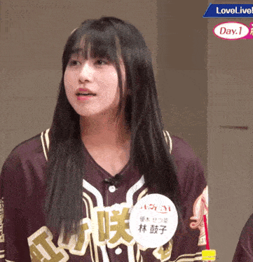a girl wearing a jersey that says love live day 1