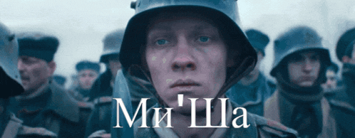 a man in a helmet stands in front of a crowd of soldiers with the words ми ша written on the bottom