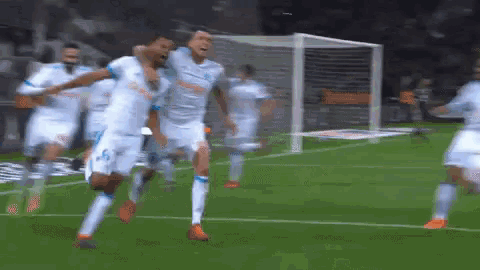 a group of soccer players celebrate a goal on the field