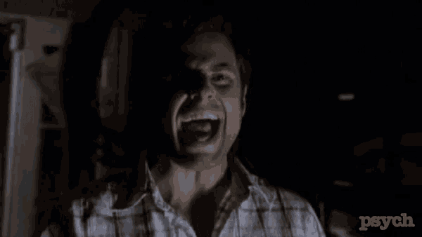 a man in a plaid shirt is screaming in the dark with the word psych behind him