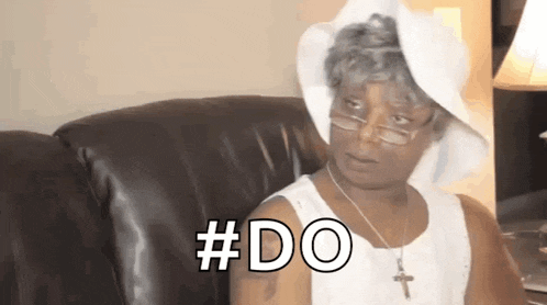 a woman is sitting on a couch wearing a white hat and glasses and saying `` # do '' .