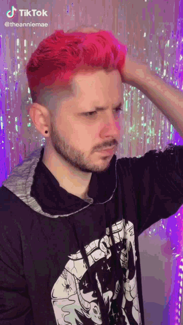 a man with red hair and a beard is wearing a black shirt with a picture of a cat on it