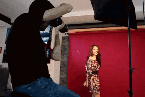 a man is taking a picture of a woman wearing a dress with a canon camera strap