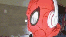 a spider man mask is wearing headphones and looking at the camera