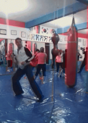 a group of people are practicing martial arts in a gym with a sign above them that says rrr