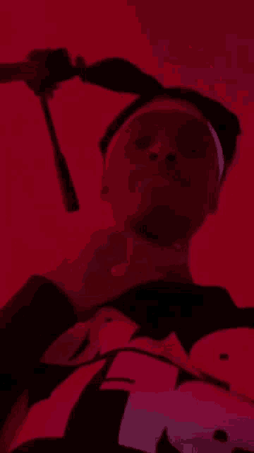 a person is wearing a hat and sunglasses in a red room .