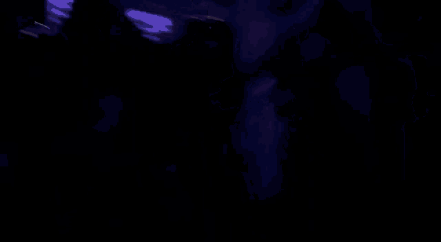 a purple object is floating in the air in the dark