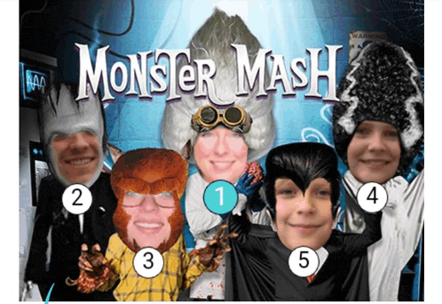 a group of people are posing for a picture in front of a monster mash poster
