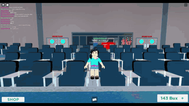 a girl in a blue shirt is standing in front of a row of empty seats in an auditorium