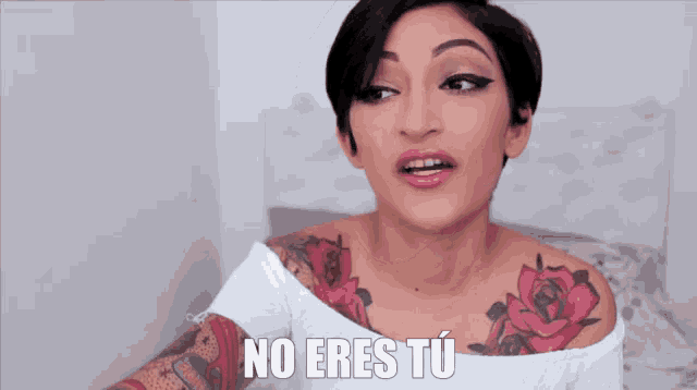 a woman with a tattoo on her shoulder says " no eres tu "