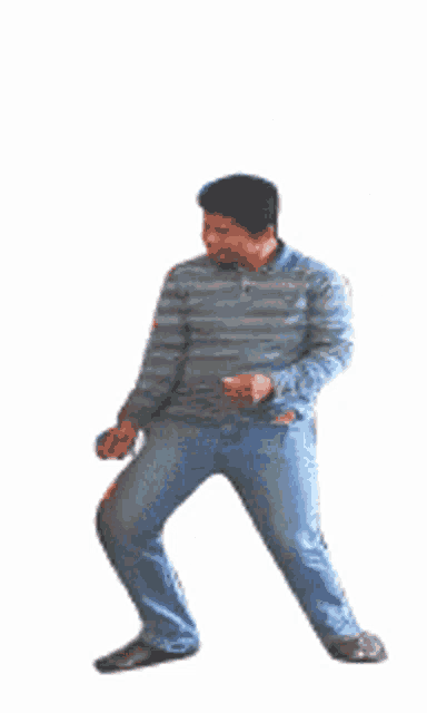 a man in a striped shirt and blue jeans is dancing