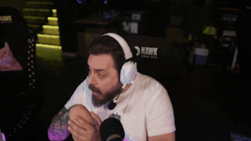 a man wearing headphones is sitting in front of a chair that says hawk