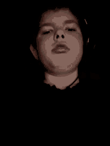 a close up of a child 's face in the dark with a black background .