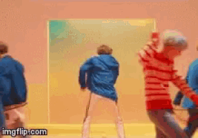 a group of people are dancing in a room with a yellow wall .