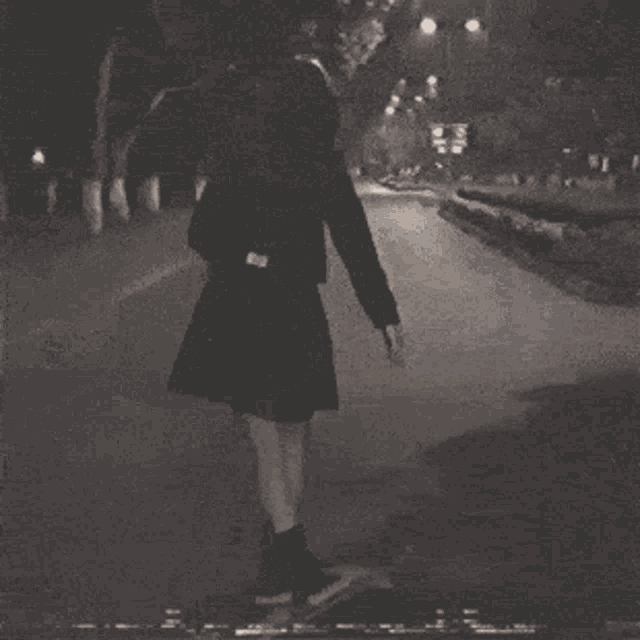 a black and white photo of a girl riding a skateboard