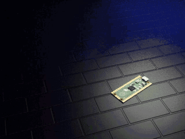 a small electronic device is laying on a dark brick floor