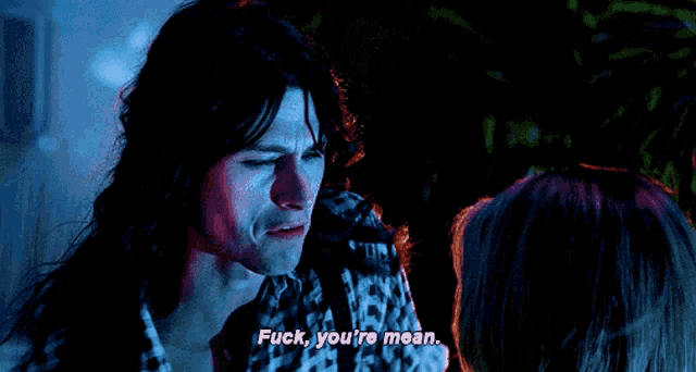 a man with long hair says " fuck you 're mean " to a woman