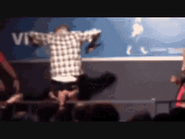 a man in a plaid shirt is dancing in front of a sign that says vfr