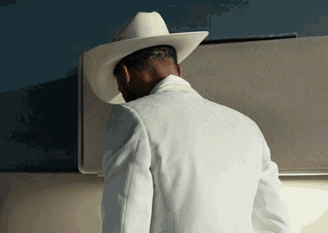 a man wearing a cowboy hat and a white jacket