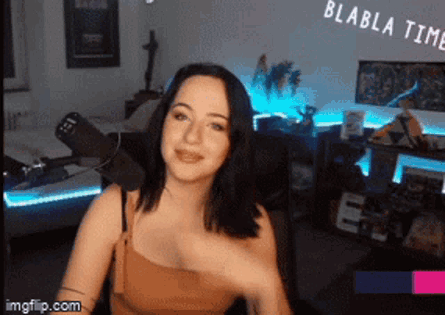 a woman is sitting in front of a microphone with the words blabla time written above her