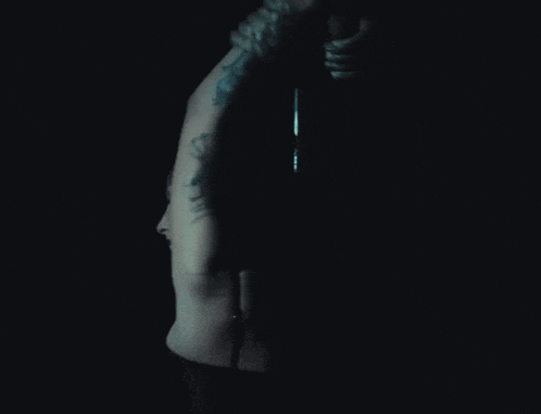 a silhouette of a person holding a blue light in their hand