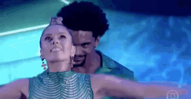 a man and a woman are dancing together on a stage in a dark room .