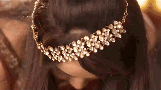 a close up of a woman wearing a gold headpiece