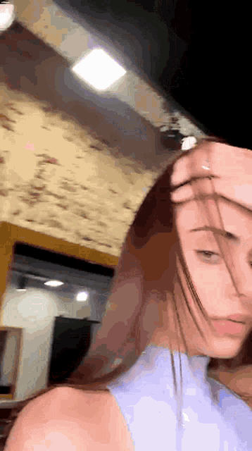 a woman covering her face with her hair while standing in a room