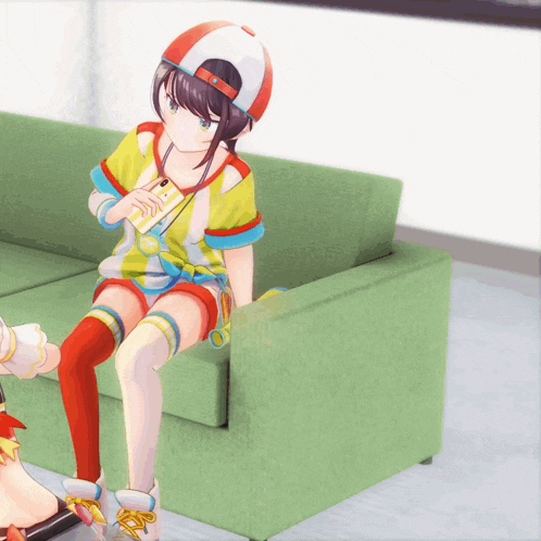 a girl sitting on a green couch holding a card that says ' a ' on it