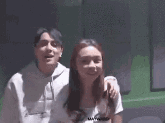 a man and a woman are standing next to each other and smiling .