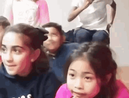 a group of young girls are sitting on top of a man 's back .