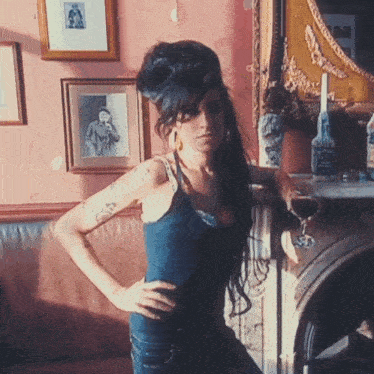 a woman standing in front of a fireplace with a bottle of jack daniels on it