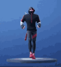 a man in a black and red hoodie is dancing on a stand .