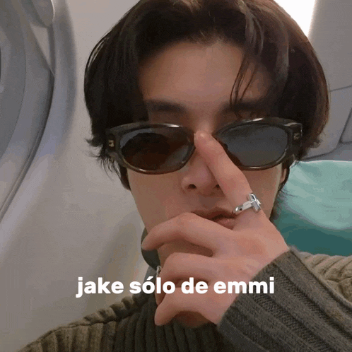 a man wearing sunglasses has a ring on his finger and the words " jake solo de emmi " on the bottom