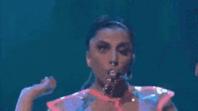 a woman in a neon green skirt is dancing on a stage .