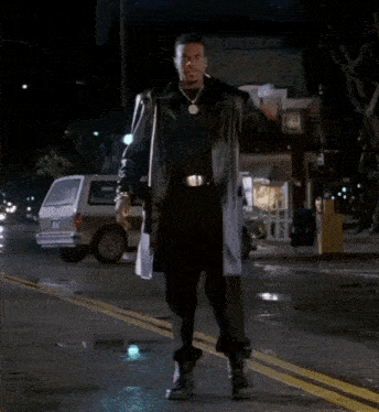 a man is dancing on the street in front of a store that says ' pop shop ' on it