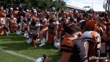 a group of football players kneeling on the field with one wearing a number 2 jersey