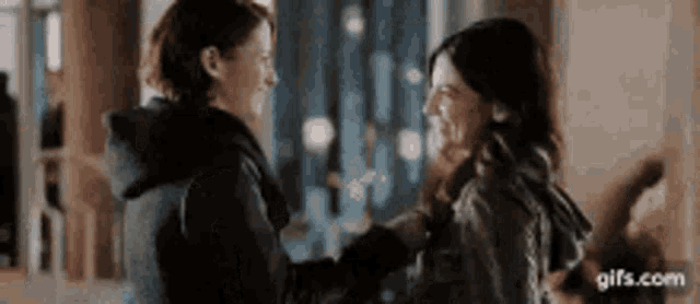 two women are standing next to each other and hugging each other .