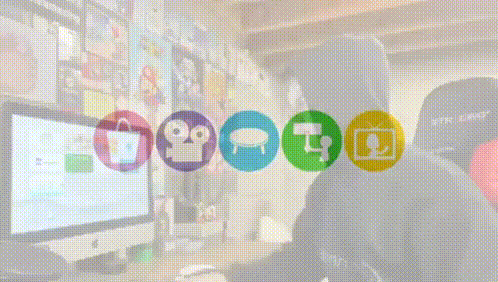 a man in a black hoodie is sitting in front of a computer