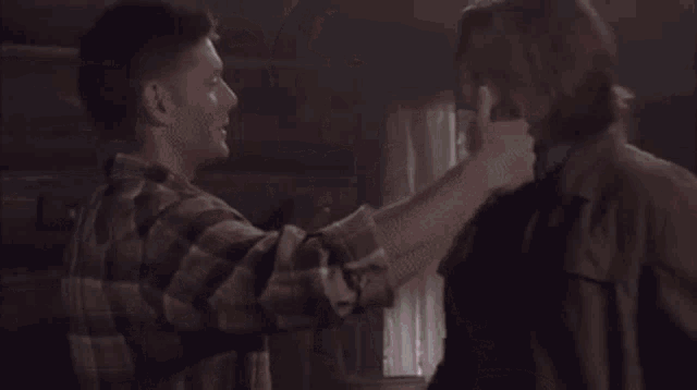 a man and a woman are hugging each other in a room .