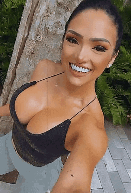 a woman taking a selfie with her breasts visible